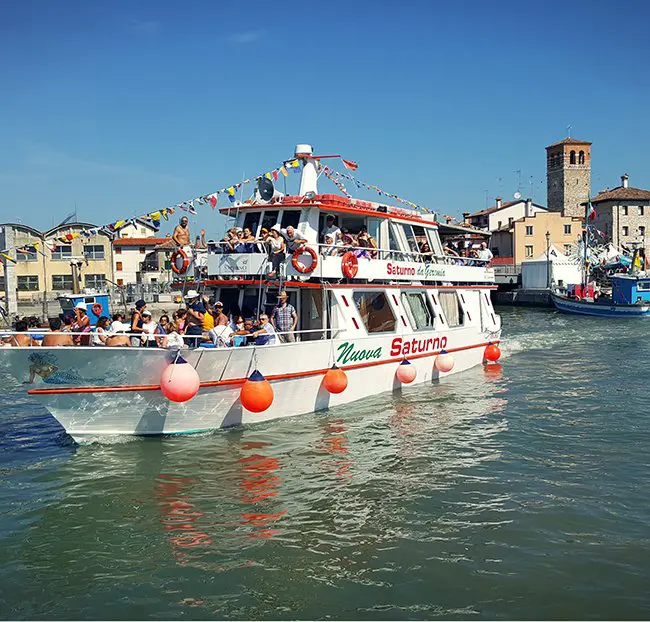 imbarcazione appena salpata dal porto con varia gente sopra